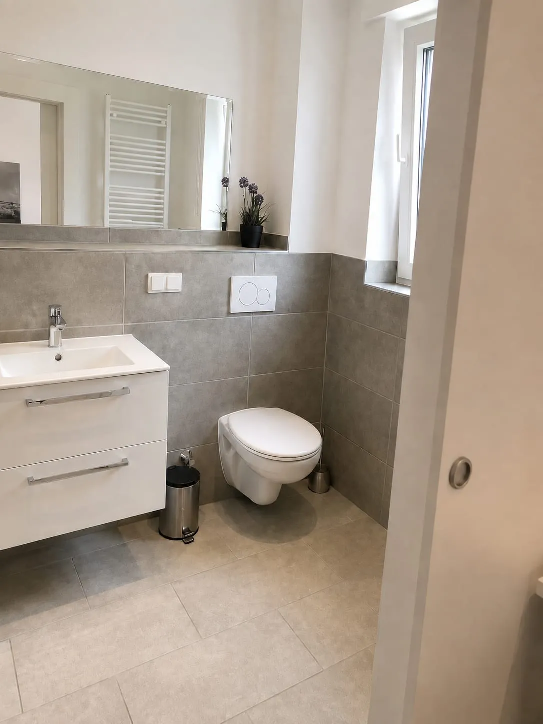 Badezimmer mit Waschtisch, Spiegel und wandhängendem WC