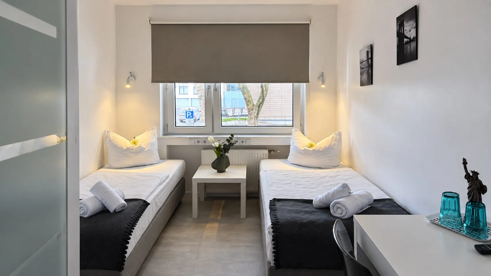 Doppelzimmer mit zwei getrennten Betten in einem schmalen Zimmer mit kleiner Sitzecke